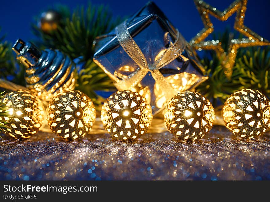 Christmas Gold Garland, Gift And Fir Tree With Decoration On Blue Background.