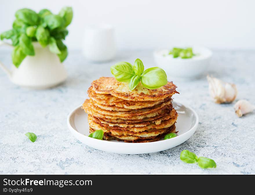 Potato pancakes with fresh herbs and sour cream, selective focus