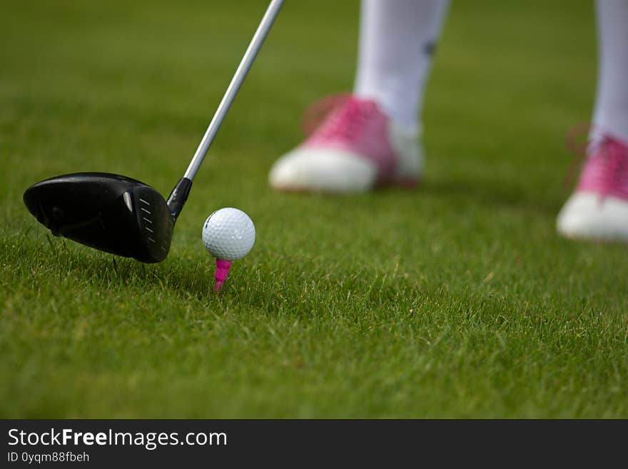 A golfer prepares to hit the ball with a driver