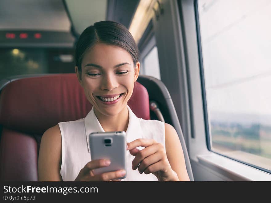 Train travel mobile phone Asian business woman using cellphone texting during commute to work. Commuting people