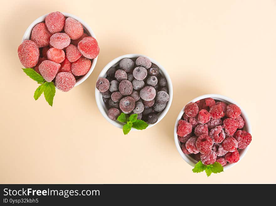 Frozen Blueberries, Strawberries And Raspberries In Bowls On A Neutral Background. Freezing Food. Long-term Storage. Copy Space