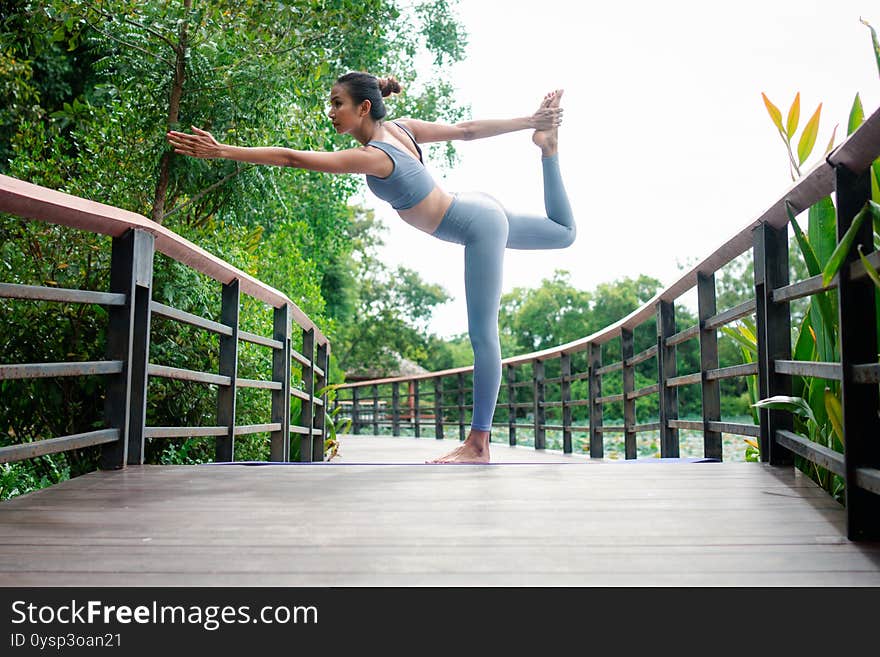 Portrait of a young woman doing yoga in the garden for a workout. Concept of lifestyle fitness and healthy. Asian women are