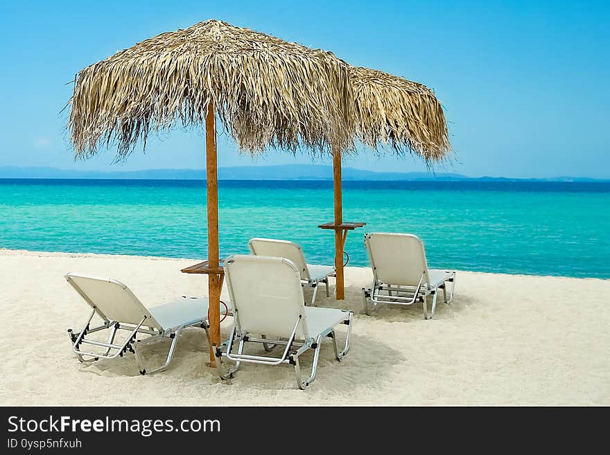 A Beautiful Beach Chairs Near The Seashore Of Greece On The Nature Background