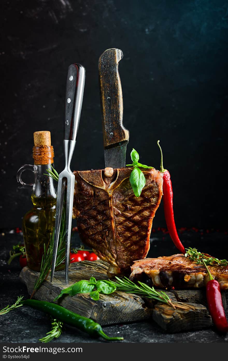 Juicy grilled steak from Angus with spices and herbs on a black background. Bull Angus. Top view. Rustic style