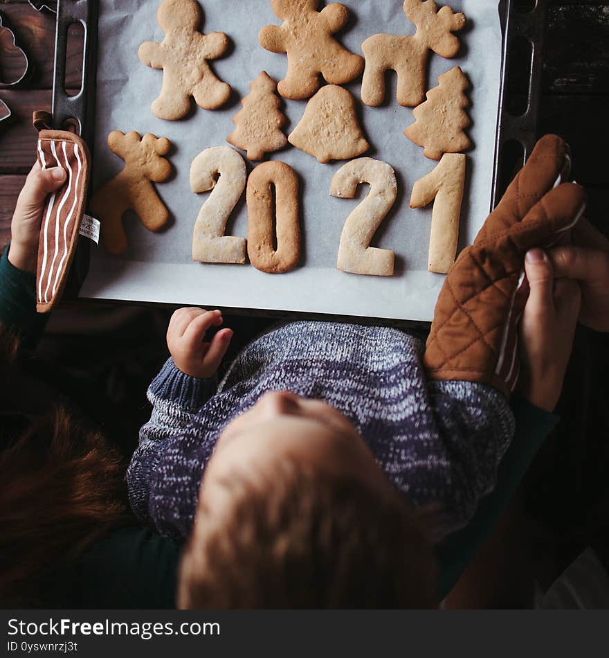 2021 celebrating New Year, Christmas magic, holiday vibes. Little boy and parents with gingerbread cookies. Family values