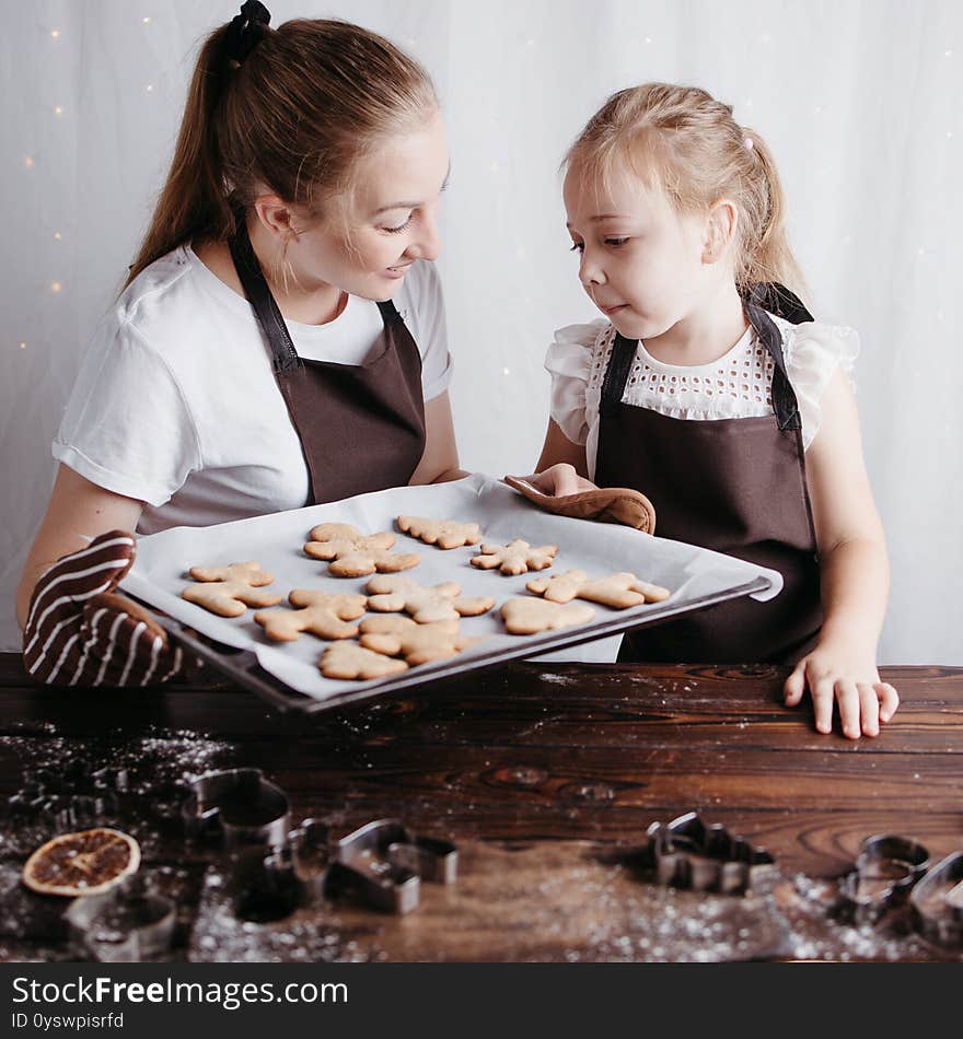 Christmas and New Year traditions concept. Festive food, cooking process, family culinary. Mother and daughter baking fresh gingerbread cookies together. Christmas and New Year traditions concept. Festive food, cooking process, family culinary. Mother and daughter baking fresh gingerbread cookies together