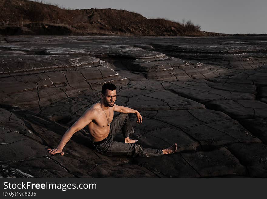 Attractive Tanned Man On The Black Sand