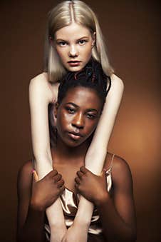 Two Pretty Girls African And Caucasian Blond Posing Cheerful Together On Brown Background, Diverse Lifestyle People Stock Image