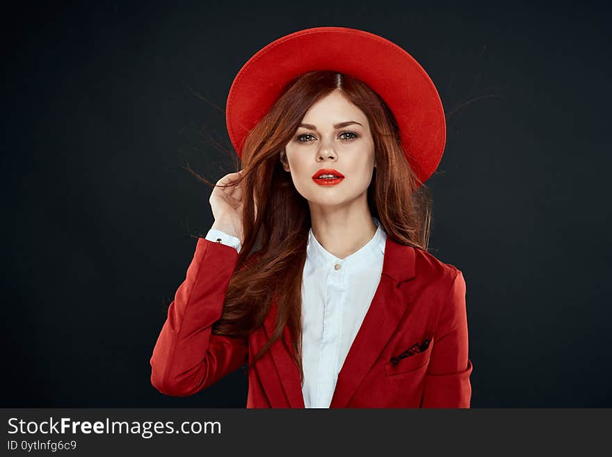 Pretty woman with red lips hat on her head jacket elegant style charm dark isolated background. High quality photo