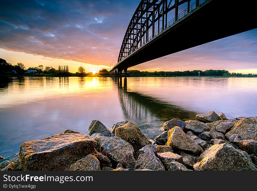 Striking arch bridge spans the river during the sunrise