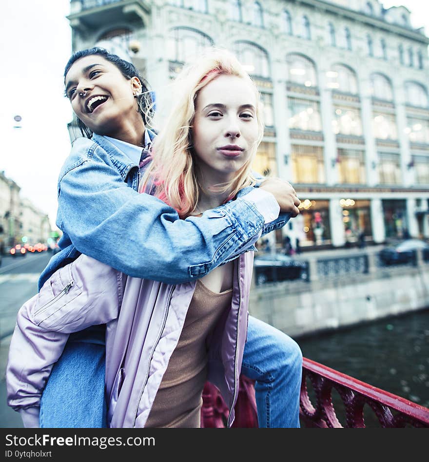 Two teenage girls infront of university building smiling, having fun, lifestyle real people concept