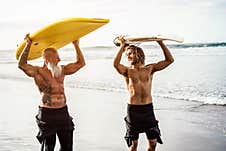 Multigeneration Friends Going To Surf On Tropical Beach - Family People Having Fun Doing Extreme Sport - Joyful Elderly And Royalty Free Stock Image