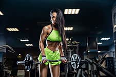 Young Beautiful Girl Athlete Bodybuilder Does Exercises In The Modern Gym. Concept - The Power Of Beauty, Fashion, Diet, Sports Royalty Free Stock Photos