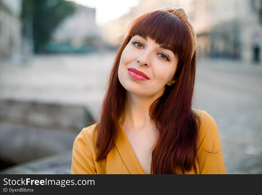 Close Up Face Portrait Of Young Smiling Charming Caucasian Woman Wearing Yellow Clothes, Posing To Camera Outdoors