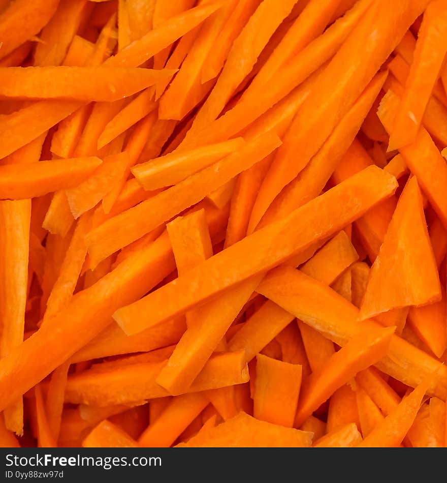 Coarsely chopped orange carrot. The process of cooking pilaf. Fresh natural vegetables background