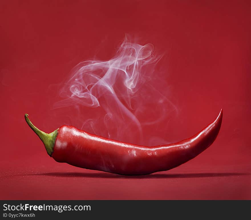 Red Hot Chili Pepper On Red Background With Smoke. Still Life With Steam Mexican Paprika