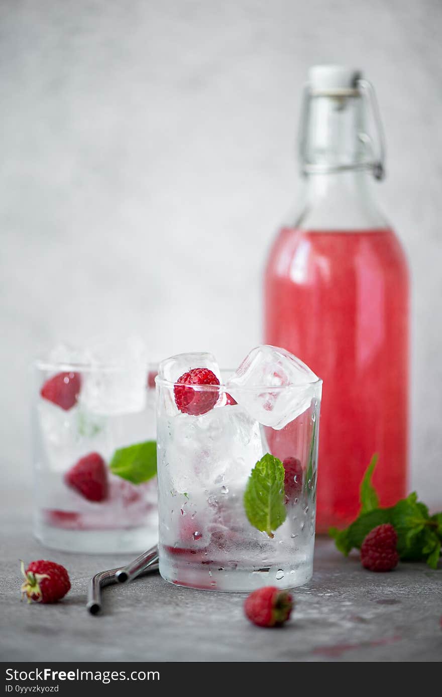 homemade raspberry lemonade in a bottle and glasses with ice