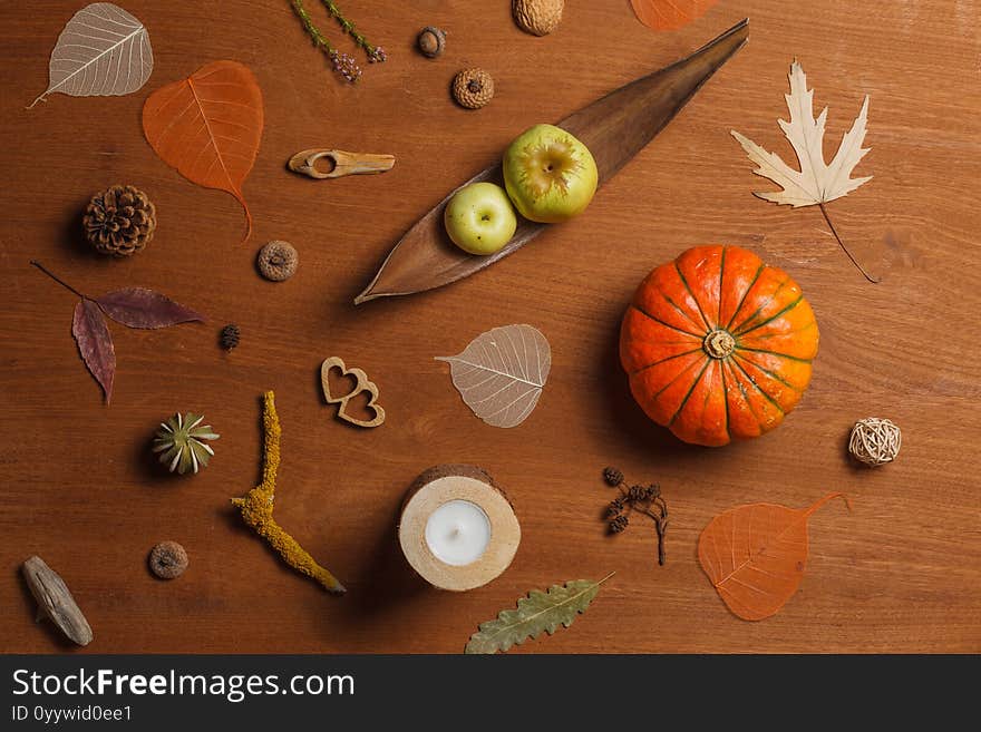 Layout on a wooden background with orange pumpkin, apples and dry leaves. Autumn lifestyle. filled frame. Horizontally,over the head. Layout on a wooden background with orange pumpkin, apples and dry leaves. Autumn lifestyle. filled frame. Horizontally,over the head