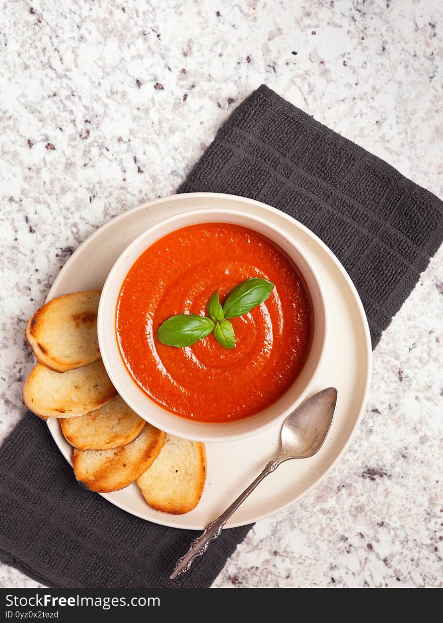 Overhead view of vegan tomato soup on a granite surface