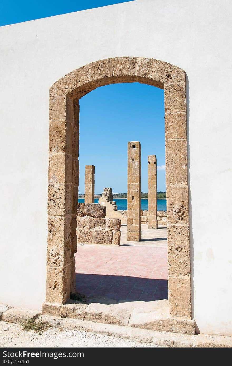 Through a door of an old tuna-fishery building in Vendicari nature reserve, Sicily, Italy