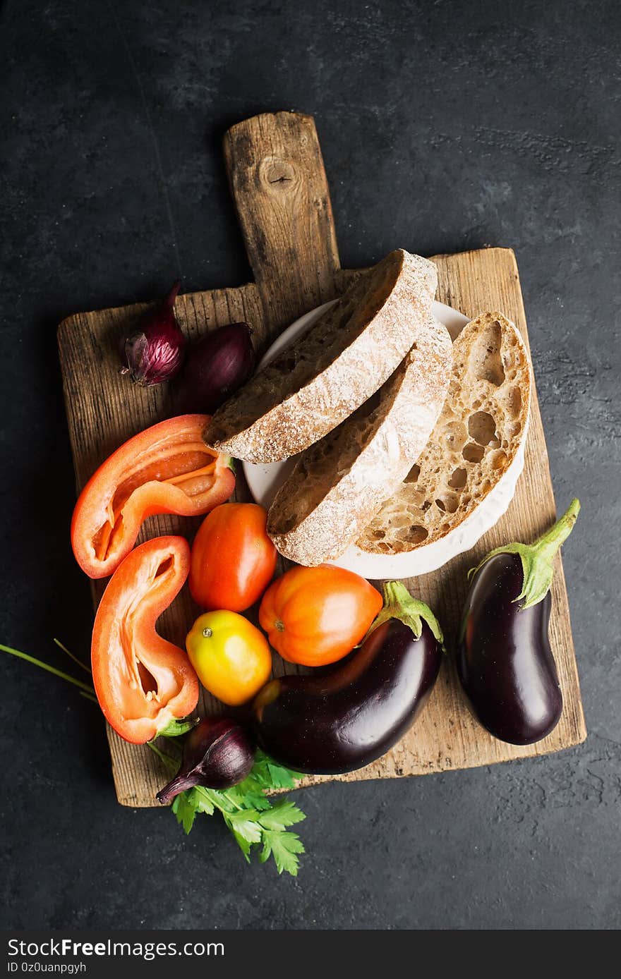 Bread salad with eggplants, tomatoes, onions, capsicum ingredients for fresh preparation. Comfortable simple meal for the whole family. Top view. Flat lay