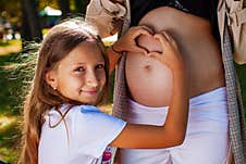 Pregnant Woman With Her Daughter In The Park Stock Photography