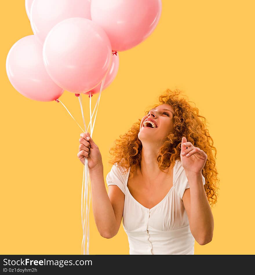 Excited beautiful redhead woman with pink balloons