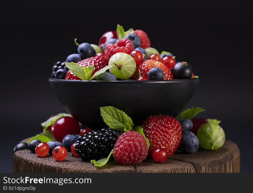 Mix of wild berries on black background