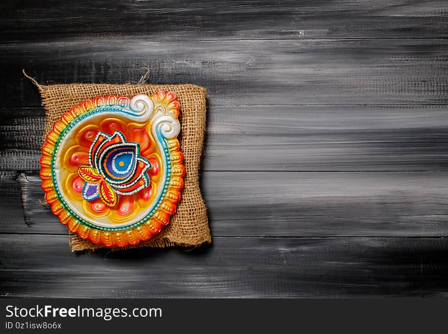 Happy Diwali Greeting Card made using sweets, or fire crackers or Diya or flowers, selective focus. Diya lamps lit during diwali celebration