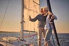 Beautiful Senior Couple Hugging And Smiling While Making Selfie On Smartphone, They Are Standing On The Side Of Sailboat Stock Images