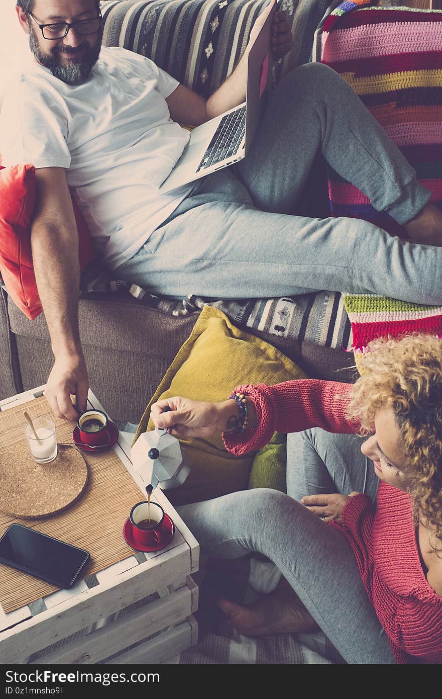 Adult happy couple at home in autumn season and coloured decorations around - real life scene with caucasian people in breakfast activity morning together