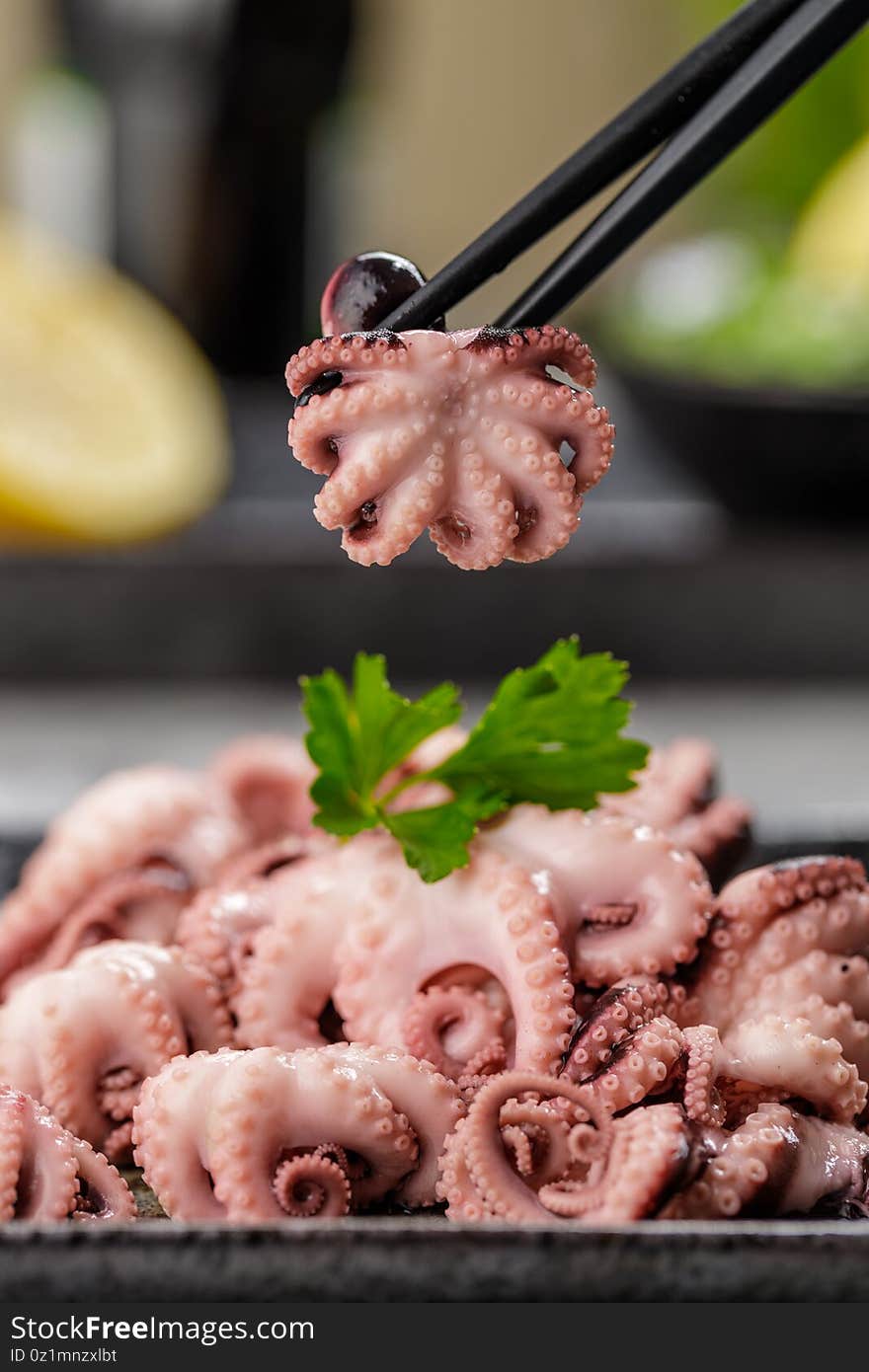 Delicious mini boiled octopus and fresh wakame seaweed salad with sesame seeds, lemon and soy sauce. Traditional japanese food concept. Delicious mini boiled octopus and fresh wakame seaweed salad with sesame seeds, lemon and soy sauce. Traditional japanese food concept.