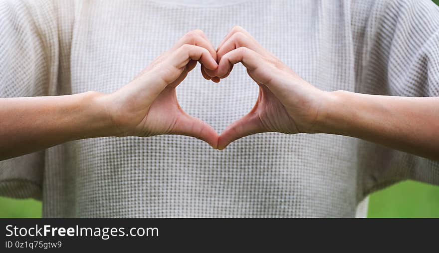 A woman making heart hand sign