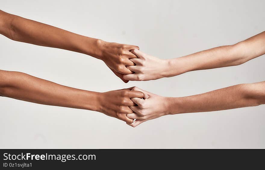 Close up of female hands holding together with fingers crossed isolated over grey background. Diversity, support, friendship concept. Web Banner