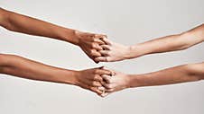 Close Up Of Female Hands Holding Together With Fingers Crossed Isolated Over Grey Background. Diversity, Support Royalty Free Stock Images