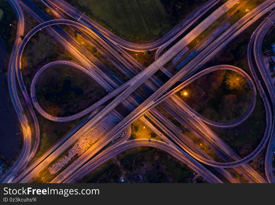 Aerial view ring road bridge and interchange freeway motorway connecting the city with headlights cars moving at night in Thailand. Aerial view ring road bridge and interchange freeway motorway connecting the city with headlights cars moving at night in Thailand