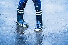 Autumn Rainy Weather. Child Wearing Rain Boots Dancing In Puddles After Rain Stock Images