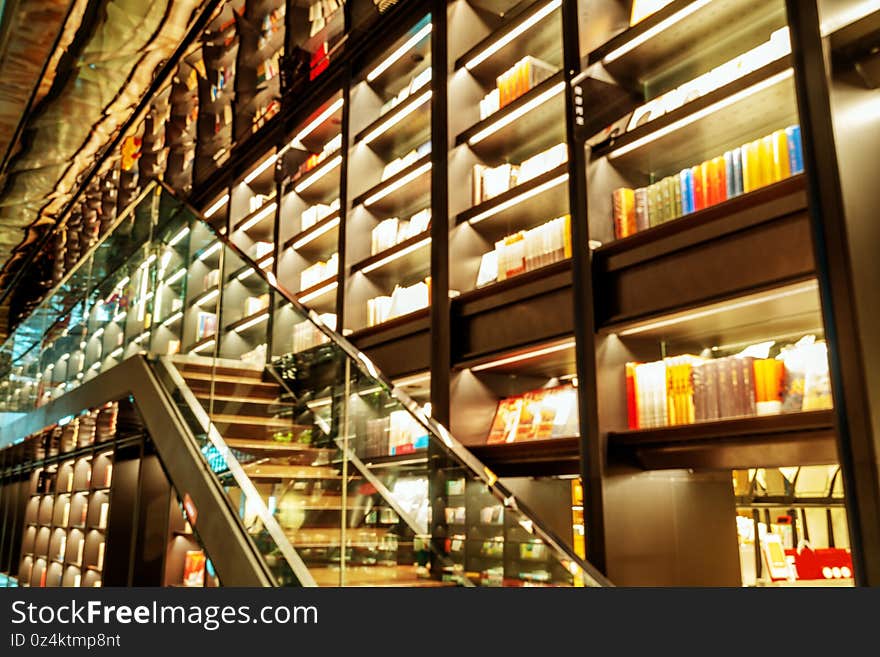 The public library collection is blurry, with a dazzling array of tall bookshelves. The public library collection is blurry, with a dazzling array of tall bookshelves