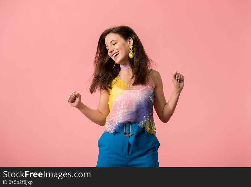 Young stylish disco girl dancing isolated on pink