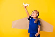 Kid Little Boy Smile Wear Pilot Hat Play And Goggles With Toy Cardboard Airplane Wings Stock Photos