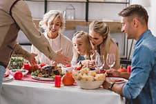 Family Members Sitting At Table And Grandfather Holding Plate With Turkey Stock Image