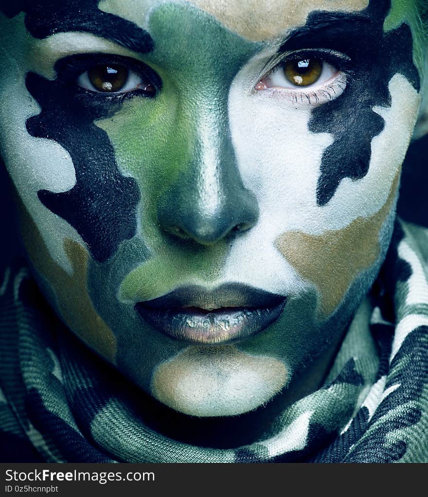 Beautiful young fashion woman with military style clothing and face paint make-up, khaki colors, halloween celebration