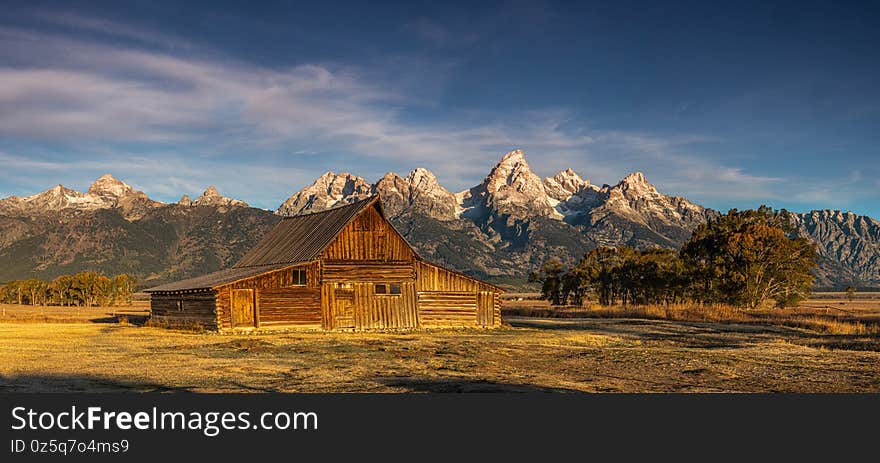 Panoramic Composition Historic T.A. Moulton Barn on Mormon Row, Antelope Flats, At Sunrise With Jagged Peaks Of The Teton Range In Background, Grand Teton National Park, Wyoming