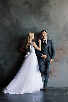 Cute Wedding Couple In The Interior Of A Classic Studio Decorated. They Kiss And Hug Each Other Royalty Free Stock Image