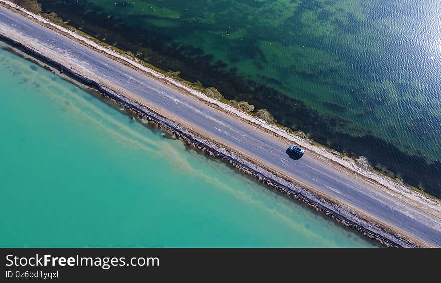 West Taijinel Lake has an area of 110.0km2 of chemical deposition of sandy dry salt lakes; it is 35.0km east of Dongtai Jinel Lake. The two lakes originally belonged to the same lake, but later separated into independent lakes due to the retreat of the lake.nThe lake area belongs to the arid and extremely arid climate of the Qaidam Desert, with an average annual temperature of about 2.0°C and annual precipitation less than 25mm. The lake water mainly relies on a small amount of melt water from ice and snow in summer. The density of the lake water is 1.217, the pH value is 7.7, and the salinity is 336.33g/L. It belongs to the salt lake of magnesium sulfate subtype. The contents of Li and B are 136.72 and 217.39 mg/L, respectively. There are rock salt deposits at the bottom of the lake, rich in resources.nNational Highway 315 runs through the center of the lake, showing blue on one side and green on the other, which is extremely beautiful and spectacular. West Taijinel Lake has an area of 110.0km2 of chemical deposition of sandy dry salt lakes; it is 35.0km east of Dongtai Jinel Lake. The two lakes originally belonged to the same lake, but later separated into independent lakes due to the retreat of the lake.nThe lake area belongs to the arid and extremely arid climate of the Qaidam Desert, with an average annual temperature of about 2.0°C and annual precipitation less than 25mm. The lake water mainly relies on a small amount of melt water from ice and snow in summer. The density of the lake water is 1.217, the pH value is 7.7, and the salinity is 336.33g/L. It belongs to the salt lake of magnesium sulfate subtype. The contents of Li and B are 136.72 and 217.39 mg/L, respectively. There are rock salt deposits at the bottom of the lake, rich in resources.nNational Highway 315 runs through the center of the lake, showing blue on one side and green on the other, which is extremely beautiful and spectacular.