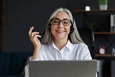 Portrait Of Smiling Grey-haired Mature Woman Using Laptop For A Online Meeting, Video Call, Video Conference Royalty Free Stock Image