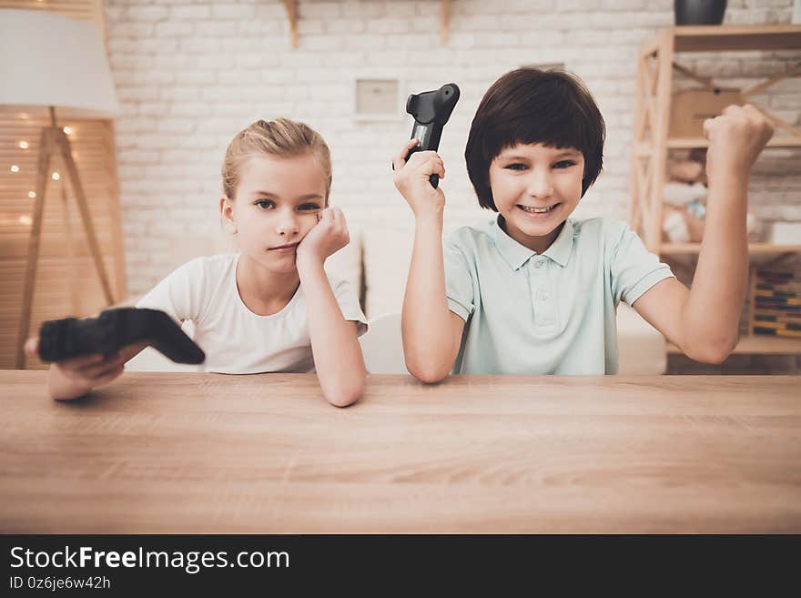 The boy rejoices that he beat the girl in the video game. Little girl upset that she lost in a video game.