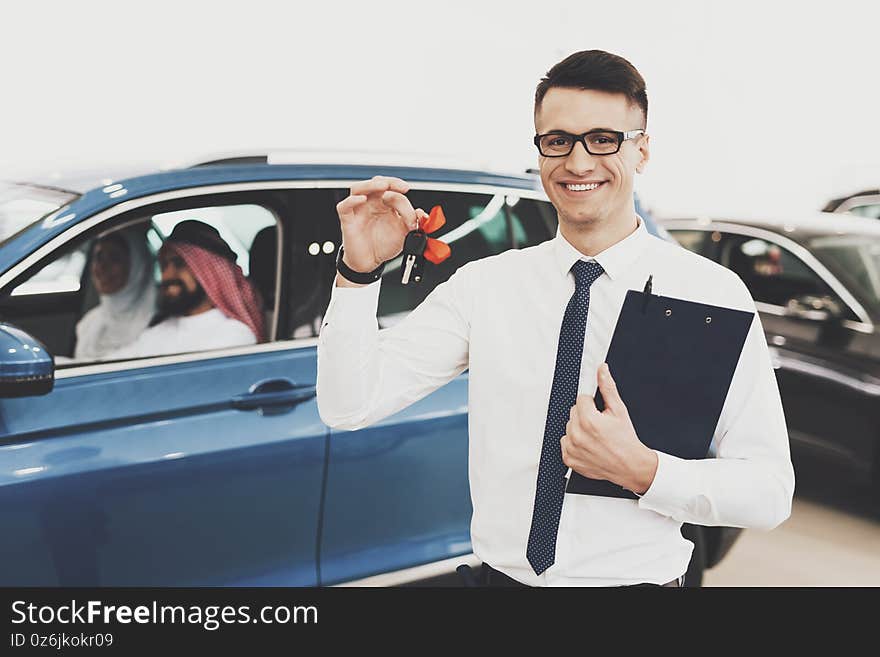 Arab family sitting in car at dealership.