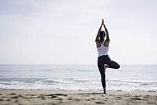 Sporty Young Woman Doing Yoga Exercises Using A Gym Mat Along The Beach In Lisbon, Portugal. Playful Woman Working As Freelance Royalty Free Stock Image