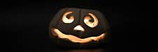 Glowing Smiling Face Halloween Pumpkin, Candle Holder, Isolated On Night Dark Black Background. Banner. Royalty Free Stock Photo